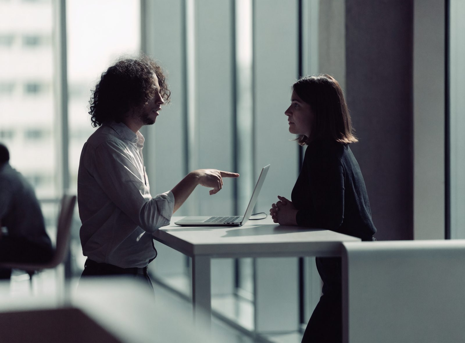Two engineers in conversation over a laptop